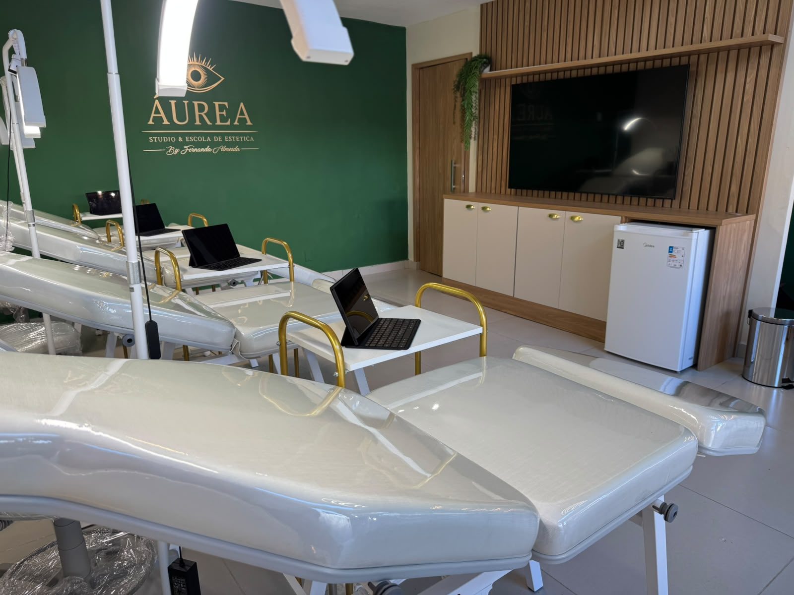 Espaço pronto para o coquetel de inauguração, com a parede da Áurea, macas e TV