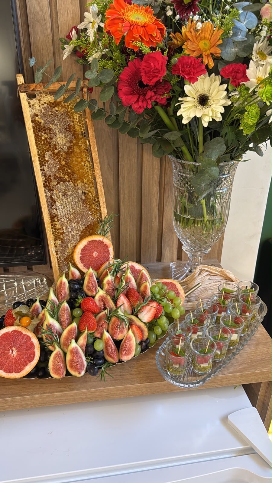 Mesa de frios do coquetel, com figos, favo de mel e frutas vermelhas
