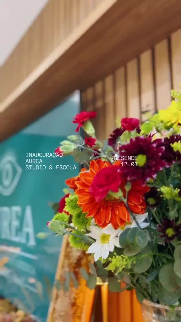 Cartela do clipe de inauguração da Áurea, com arranjo de flores