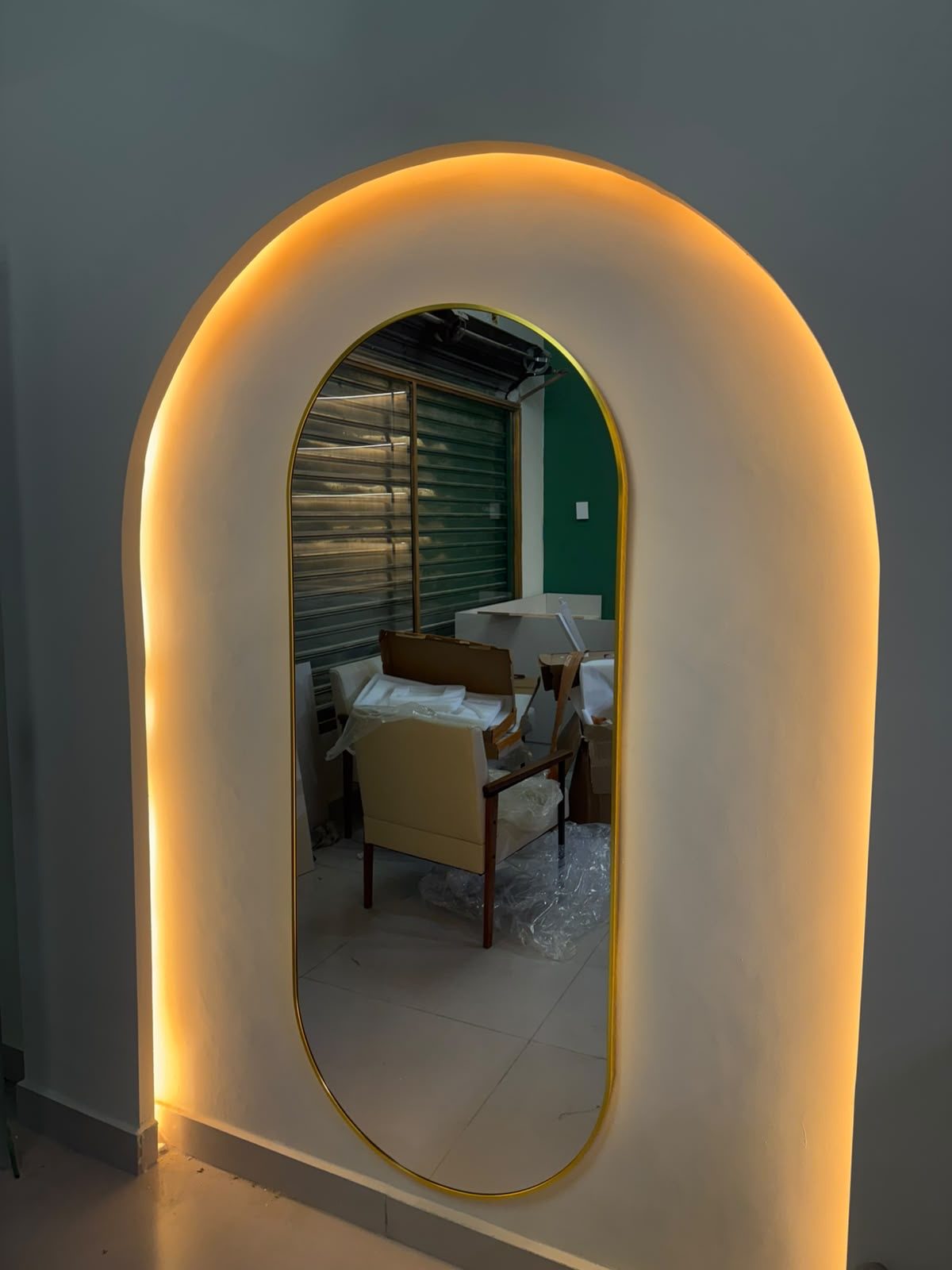 Espelho arqueado com iluminação âmbar embutida, detalhe de acabamento