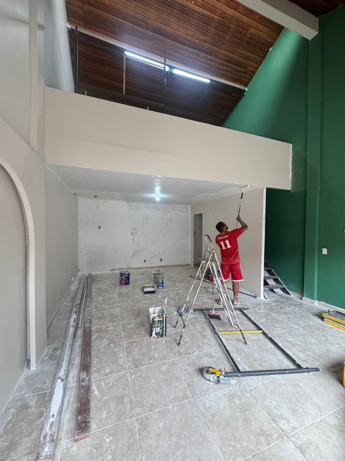 Pintura do térreo — operário em ação, verde avançando pela parede