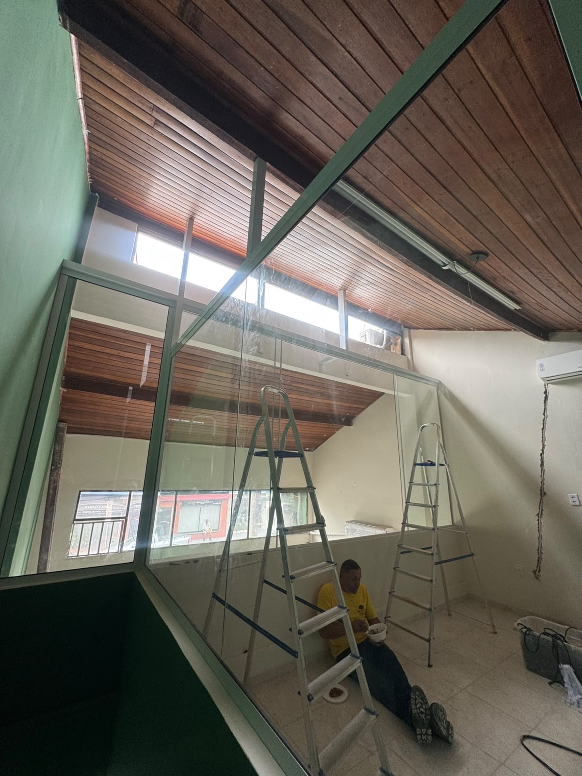 Vidro do mezanino VIP sendo fixado — detalhe da obra