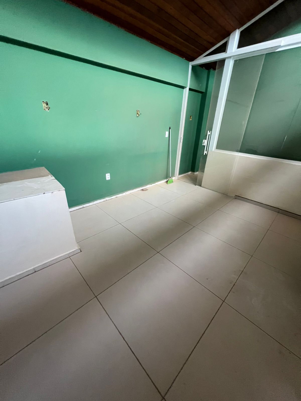 Sala finalizada — piso, parede verde e porta de vidro