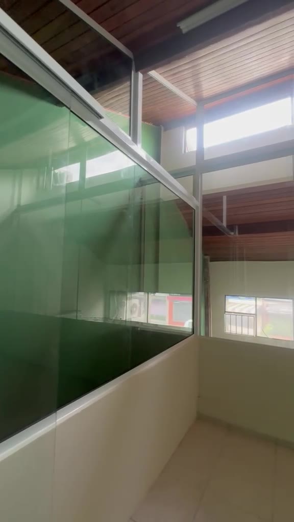 Corredor do mezanino — vidro e forro de madeira em detalhe