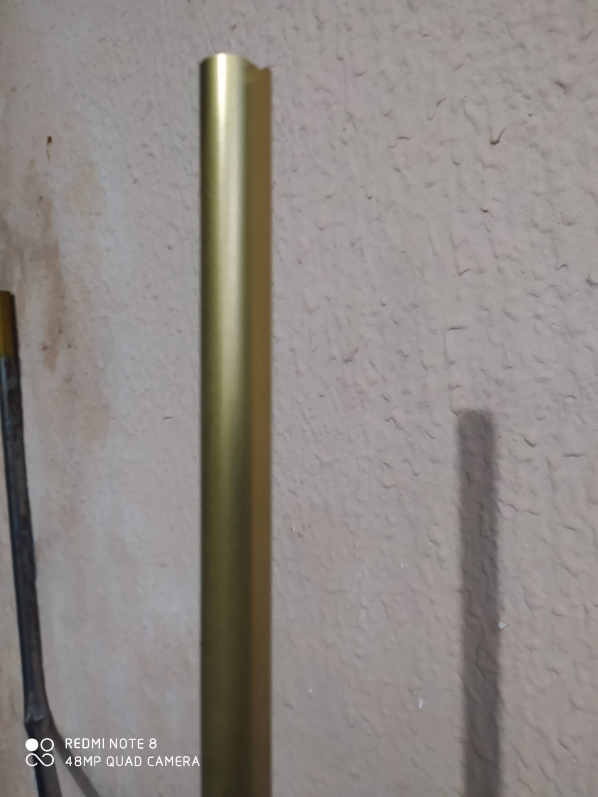 Detalhe do acabamento em perfil dourado aplicado na parede